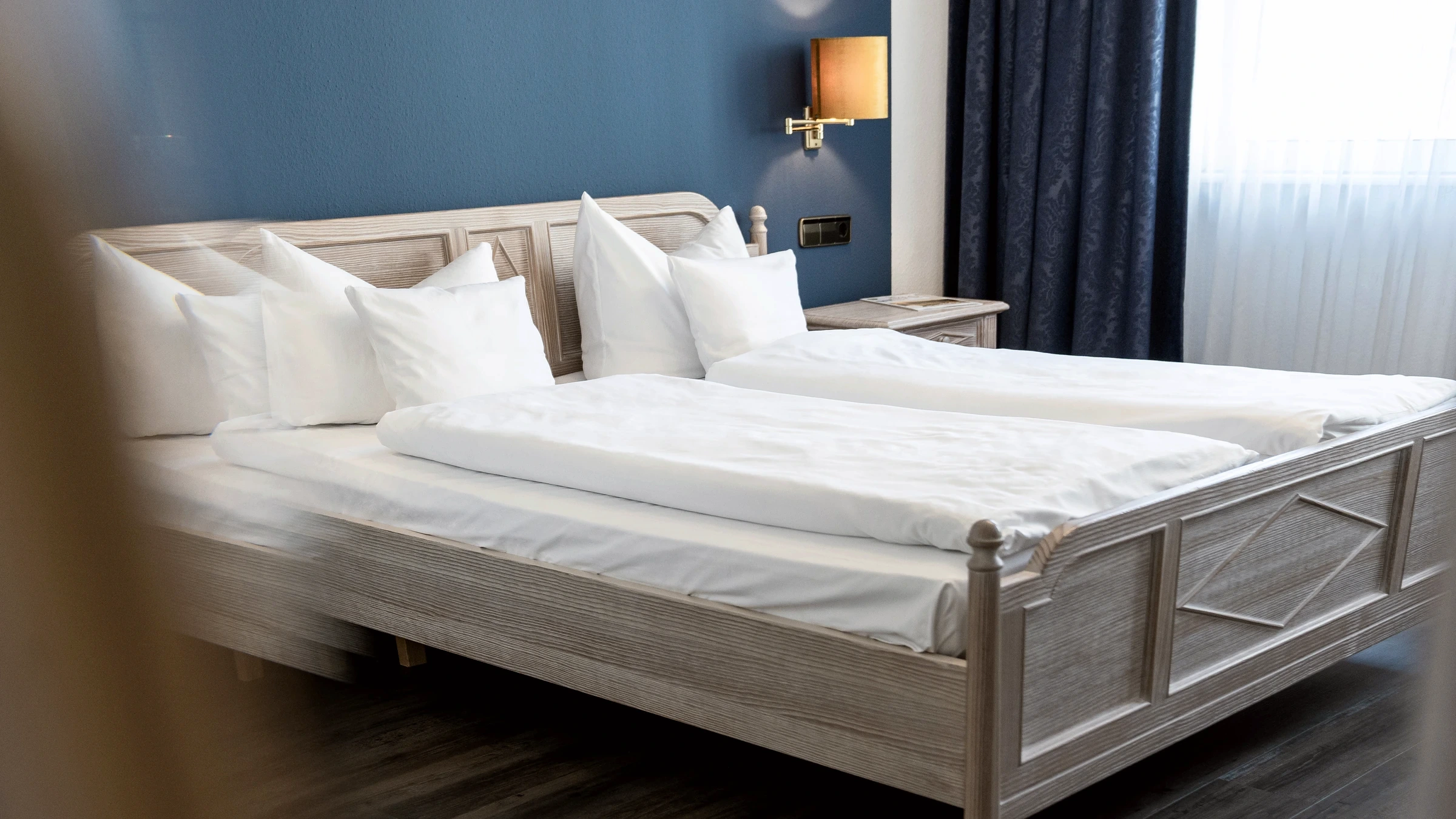 Doppelbett mit hellen Holzmöbeln im Vier Jahreszeiten