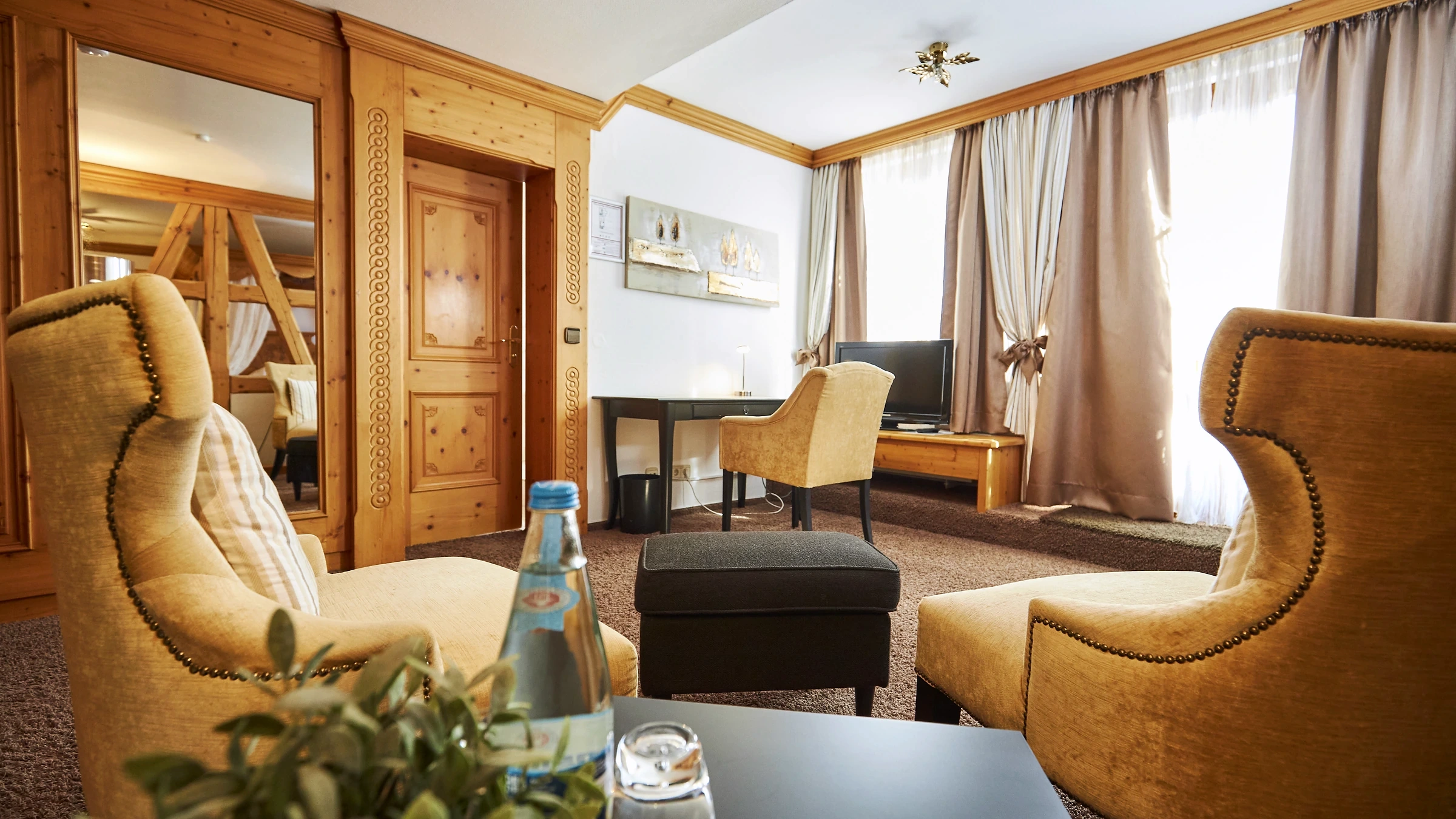 Sitzbereich der Suite mit Sesseln und Holzvertäfelung